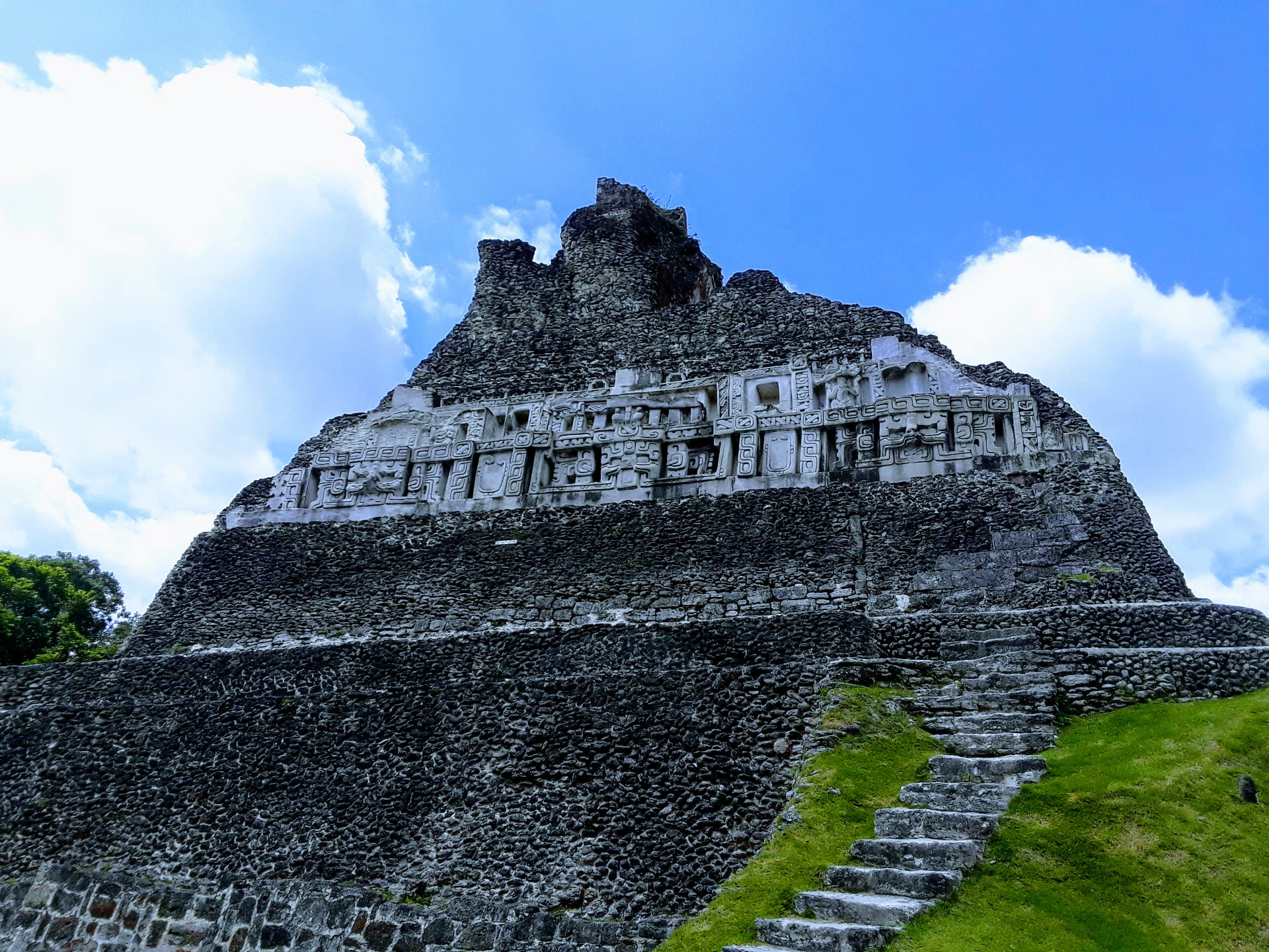 El Castillo pyramid at Xunantunich with its carved stone frieze against a blue sky