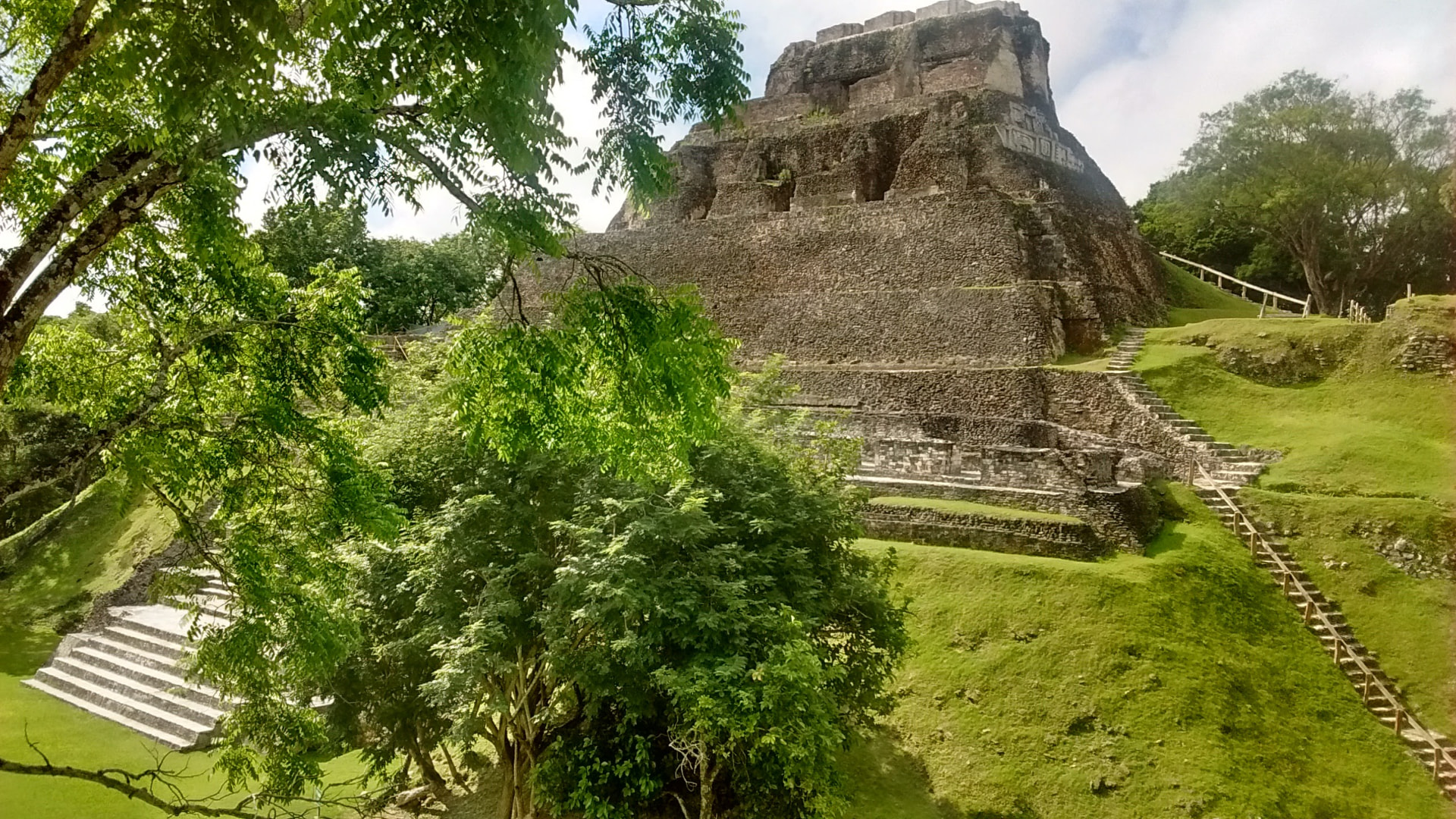 The Xunantunich Maya site surrounded by green lawns and jungle trees